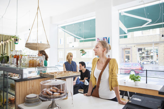 Mid adult woman waiting at cafe counter
