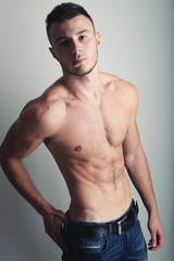Obraz premium Young handsome guy posing in a studio with a beautiful body