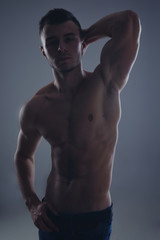Fototapeta na wymiar Young handsome guy posing in a studio with a beautiful body