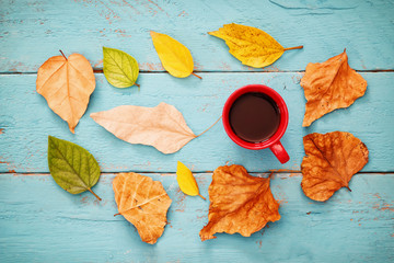 Plakat Autumn background with dry leaves and hot cup of coffee