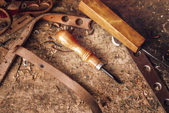Close-up of tools and waste leather on table