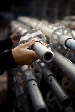 Cropped image of builder selecting pipe at construction site