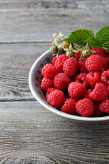 Raspberry in bowl on wooden table