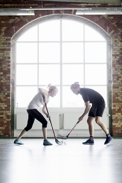Man and woman playing floorball