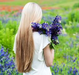 Naklejka premium girl with bouquet of lupine flowers