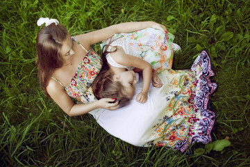 Mother and daughter in a beautiful floral sundresses in the summ