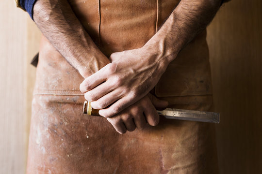Close up of carpenter's hands holding chisel