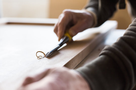 Cropped image of carpenter using chisel in workshop
