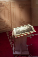 Священная для мусульман  книга  - Коран , на подставке.