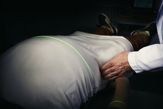 Cropped image of doctor measuring the person’s stomach through laser machine