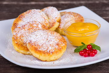 Cheese pancakes with honey in white plate.