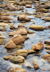 Fototapeta na wymiar Sandstone boulders in a sandy freshwater creek