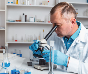 male scientific researcher using microscope in the laboratory.