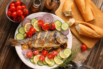Grilled fish with roasted potatoes and vegetables on the plate