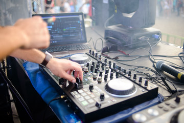 Club, disco DJ playing and mixing music for crowd of happy people. Nightlife, concert lights, flares