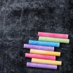 Pieces of school chalk on old black chalkboard