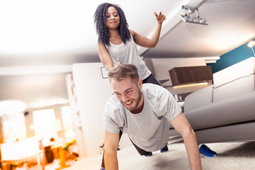 Obraz premium young couple having fun doing gymnastics at home