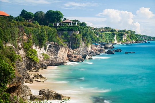 Scenic landscape of high cliff on tropical white sand Pantai beach in Bali, Indonesia