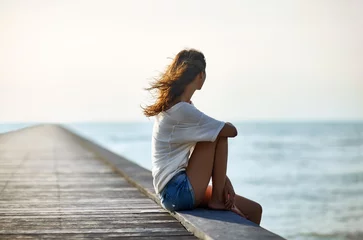 Keuken spatwand met foto Young beautiful woman sitting on the pier © GVS