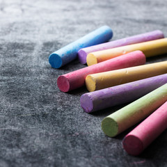 Pieces of school chalk on old black chalkboard