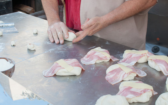 Baker making dumplings with cheese and bacon