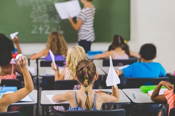 school kids with paper planes in classroom