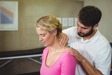 Fototapeta premium Male physiotherapist giving neck massage to female patient