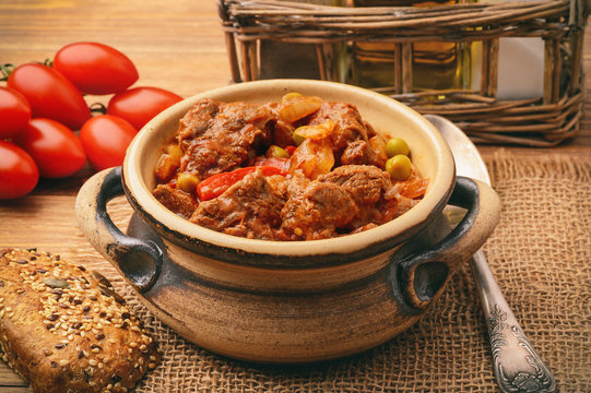 Goulash from venison meat on brown wooden background. 