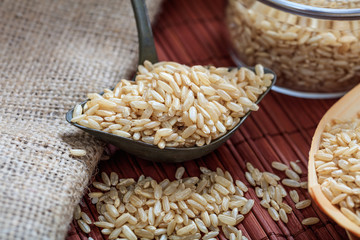 Unrefined rice and metallic old spoon