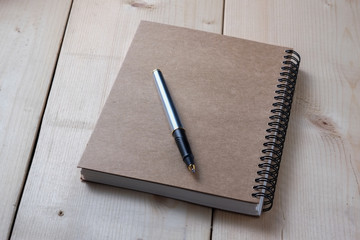 pen and book on wood background