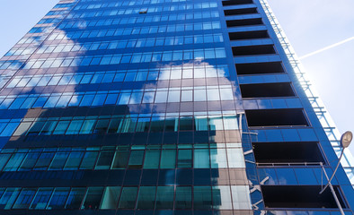 reflecting sky in glass of office building abstract background