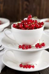 Two white cups with red currant.