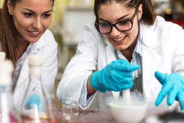 Two young female scientist  doing experiments in lab.