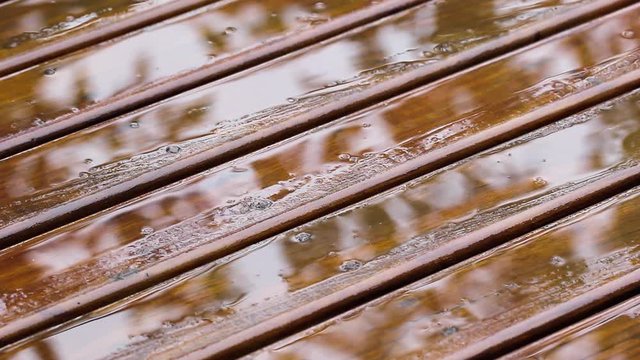Pingos de chuva no deck de madeira.