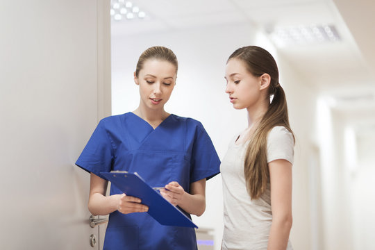 doctor or nurse with clipboard and girl patient