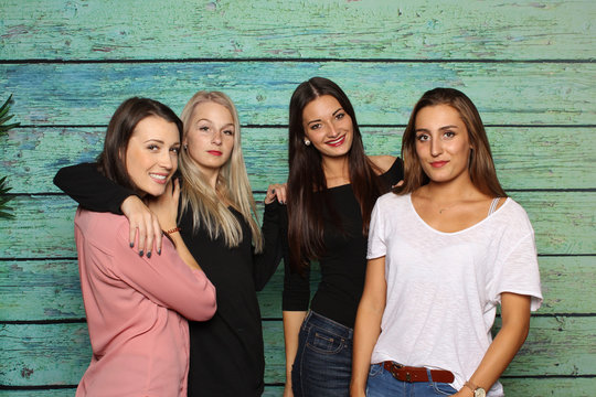 4 Freundinnen stehen vor einer Fotobox - 4 Mädchen lächeln in eine Fotobox