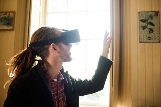 Close-up of hipster gesturing while using virtual reality simula