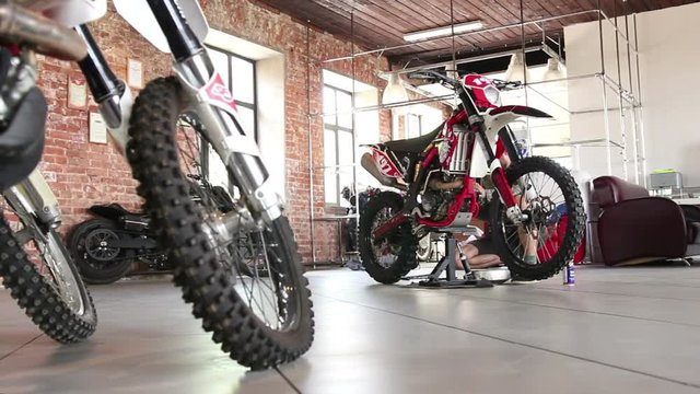 male sportsman repairing his enduro motorcycle
