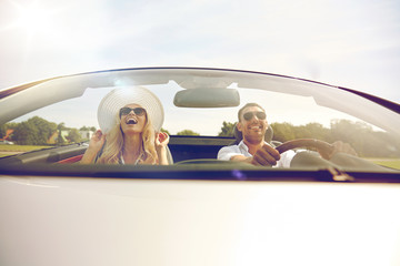 happy man and woman driving in cabriolet car