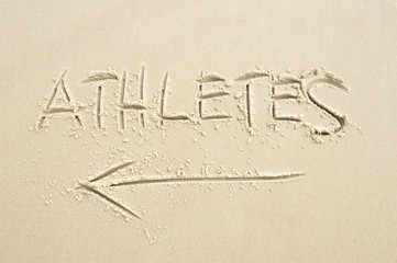 Handwritten message with arrow pointing the way for Athletes written in smooth sand in Barra, Rio de Janeiro, Brazil