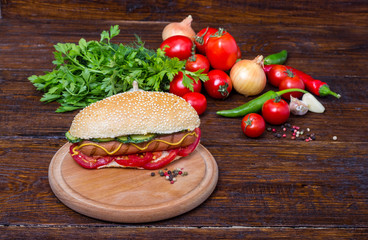 Hot dog with vegetables on background tomatoes on a wooden table