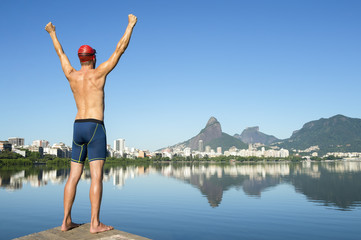 Obraz premium Athlete swimmer standing in front of the Rio de Janeiro skyline at Lagoa Rodrigo de Freitas lagoon