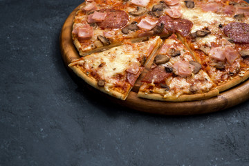 Pizza with cheese and sausage on a dark background