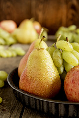 Crop Plate with pears and apples. Autumn fruits. Vertical photo.