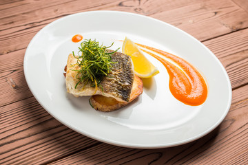 whitefish on plate restaurant on wooden table