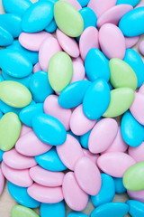 Background of pink, blue and green sugared almonds or chocolate