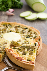 French quiche with vegetables on a rustic wooden table

