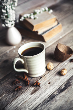 Large Cup of coffee on vintage wooden background. Spring flowers and books.