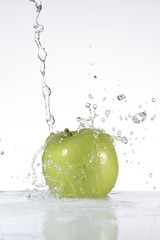 Agua cayendo sobre una manzana verde