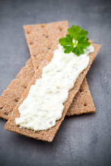 Crispbread with soft cheese with herbs and bacon.